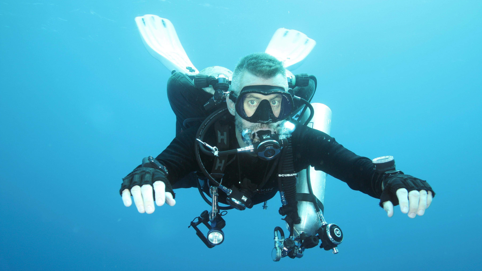 arturo marchand facing the camera underwater while scuba diving